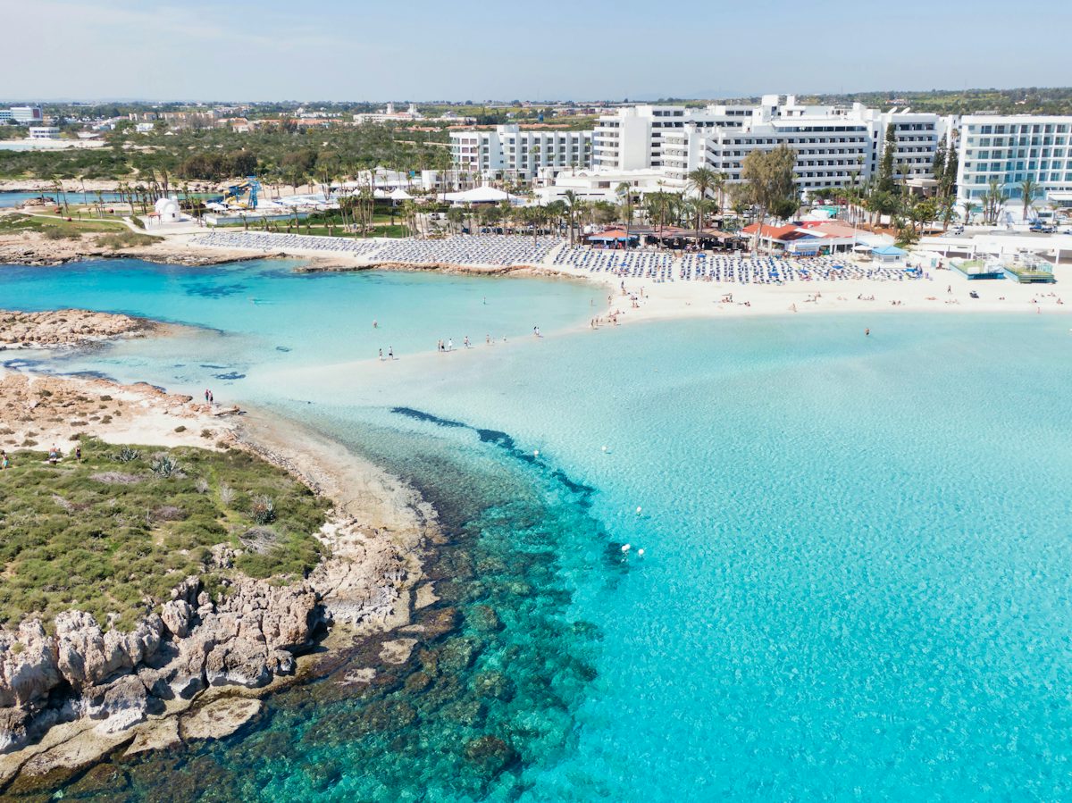 A calm turquoise bay with a Cyprus resort town behind it